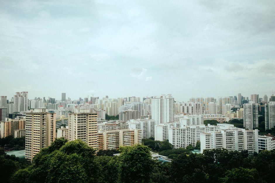 Aerial view of Singapore's urban skyline with modern architecture amidst greenery.